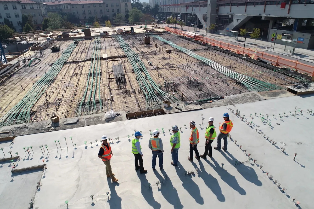 Bauarbeiter und Kräne auf einer großflächigen Baustelle